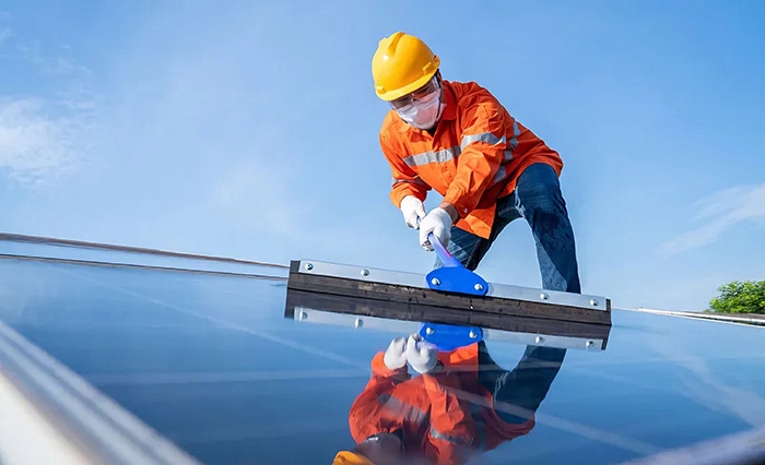 Worker is cleaning solar panels